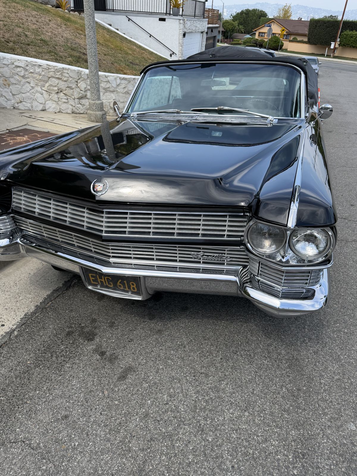 A black vintage Cadillac parked on a hillside street