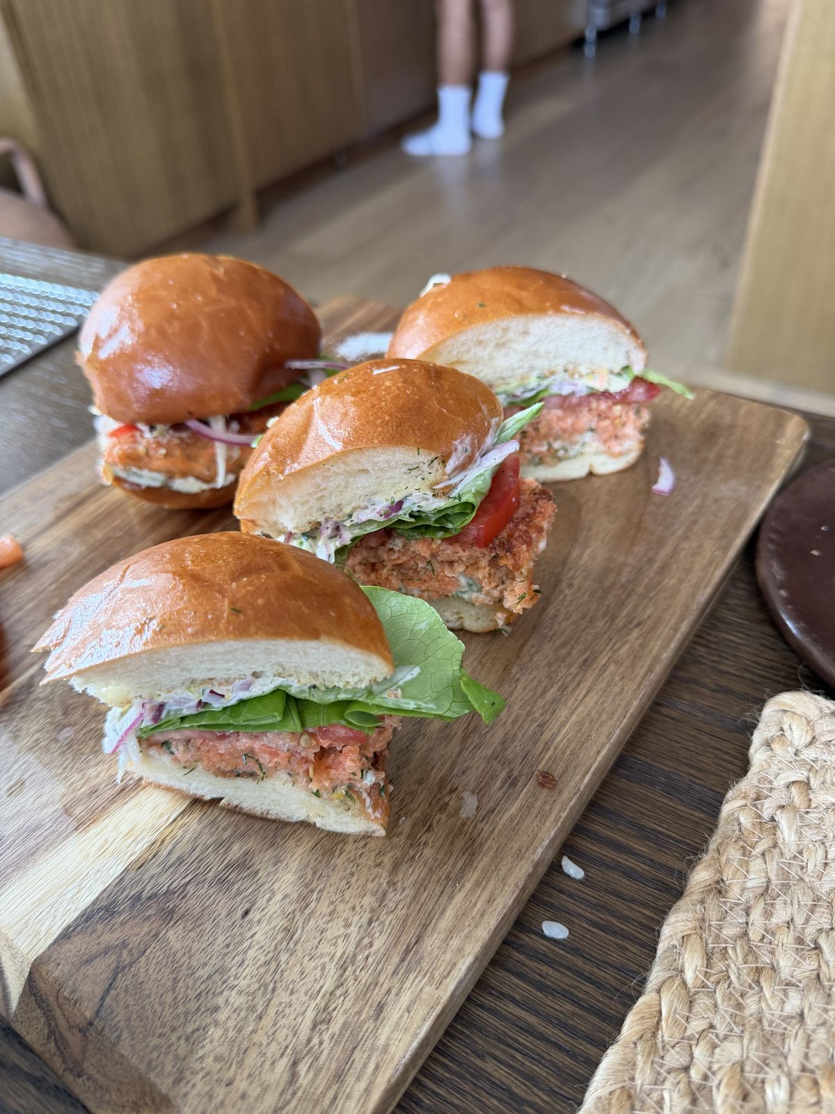 Small burgers on brioche buns on a wooden board