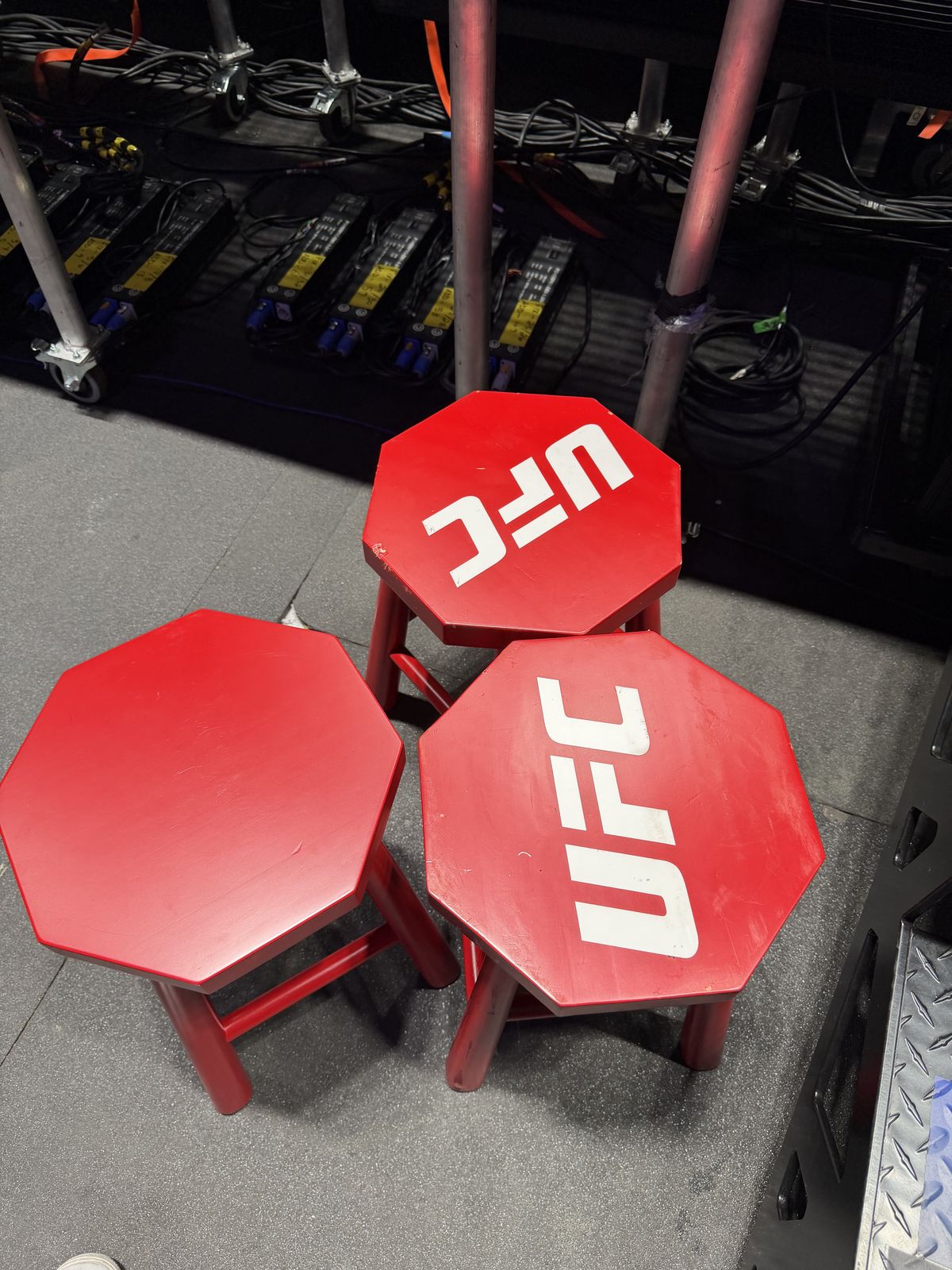 Three red UFC corner stools backstage