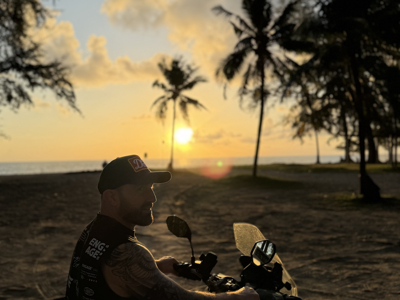A rider sitting on a motorbike at sunset