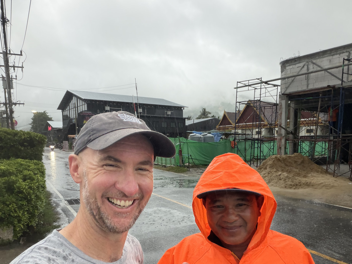Mick Baines in the rain beside someone in an orange rain poncho